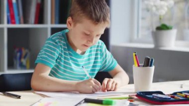 Çocuk Masa 'da ödevini yapıyor. Şirin Çocuk, Ders kitapları ve okul malzemelerinin yardımıyla evde öğreniyor. Öğrenim ve Eğitim Konsepti.