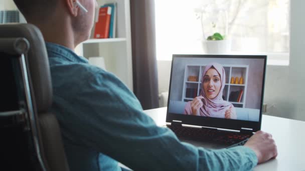 A barátja és a muszlim barátnője online beszélgetnek az interneten keresztül. A fiatalok otthon ülnek és konferenciahívást tartanak. Beszélő férfi és nő. Távoli dátum és kommunikációs koncepció. — Stock videók