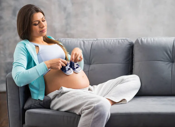 Mujer embarazada joven está descansando en casa y esperando un bebé. Embarazo, maternidad, salud y estilo de vida. — Foto de Stock