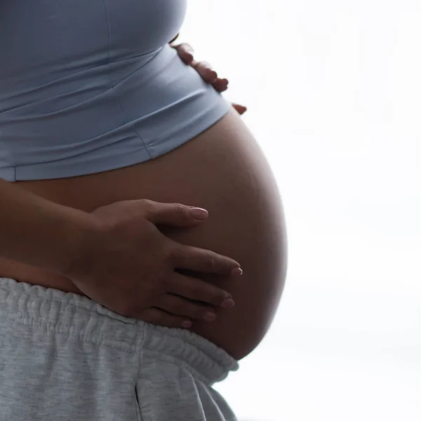 Young pregnant woman is resting at home and expecting a baby. Pregnancy, motherhood, health care and lifestyle concept. ロイヤリティフリーのストック写真