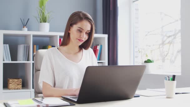 Junge Frau arbeitet im Home Office am Computer. Arbeitsplatz der Unternehmerin, Freiberuflerin oder Studentin. Fernarbeit und Bildungskonzept. — Stockvideo