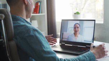 Meslektaşlar internet üzerinden çevrimiçi telefon görüşmesi yaparlar. Genç girişimciler evlerinde çalışır ve konferans görüşmeleri yaparlar. Beyaz adam ve Asyalı kadın konuşuyor. Uzak çalışma ve eğitim.