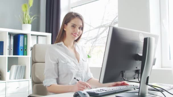 Junge Frau arbeitet im Büro am Computer. Arbeitsplatz der Unternehmerin, Managerin oder Geschäftsfrau. Fernarbeit und Bildungskonzept. — Stockvideo