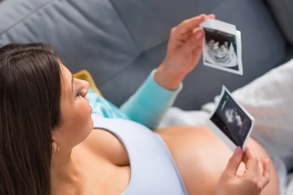 La giovane donna incinta sta riposando a casa e aspetta un bambino. Gravidanza, maternità, assistenza sanitaria e stile di vita. — Foto Stock