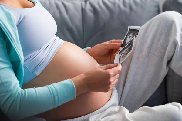 Junge schwangere Frau ruht sich zu Hause aus und erwartet ein Baby. Schwangerschaft, Mutterschaft, Gesundheitsfürsorge und Lebensstil-Konzept. — Stockfoto