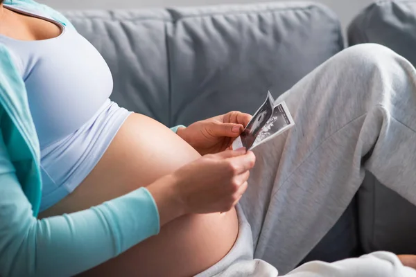 Ung gravid kvinna vilar hemma och väntar barn. Graviditet, moderskap, hälsovård och livsstil. — Stockfoto