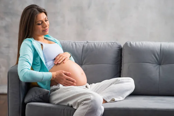 年轻的孕妇正在家中休息，等待着孩子的出生。怀孕、生育、保健和生活方式概念. — 图库照片