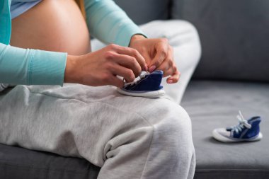 Genç hamile kadın evde dinleniyor ve bebek bekliyor. Hamilelik, annelik, sağlık ve yaşam tarzı kavramı.