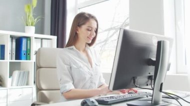 Ofiste bilgisayar kullanan genç bir kadın. Girişimci, Yönetici ya da İş Kadını 'nın işyeri. Uzaktan Çalışma ve Eğitim Konsepti.