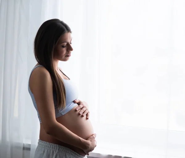 Une jeune femme enceinte se repose à la maison et attend un bébé. Grossesse, maternité, soins de santé et mode de vie. — Photo