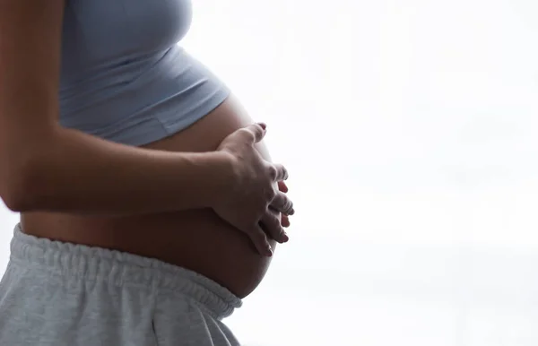 Junge schwangere Frau ruht sich zu Hause aus und erwartet ein Baby. Schwangerschaft, Mutterschaft, Gesundheitsfürsorge und Lebensstil-Konzept. — Stockfoto