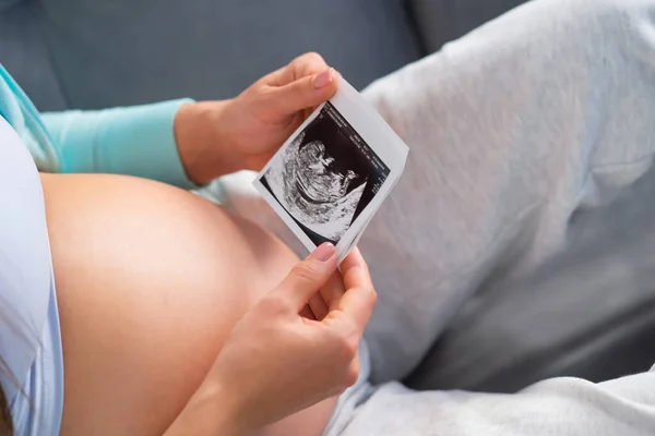 La giovane donna incinta sta riposando a casa e aspetta un bambino. Gravidanza, maternità, assistenza sanitaria e stile di vita. — Foto Stock