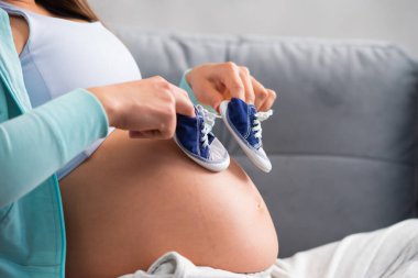 Genç hamile kadın evde dinleniyor ve bebek bekliyor. Hamilelik, annelik, sağlık ve yaşam tarzı kavramı.