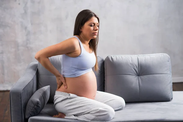 Young pregnant woman suffers from back pain. Pregnancy, motherhood, health care and lifestyle concept. — Stock Photo, Image
