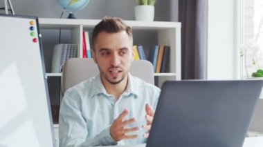 Genç Öğretmen evde bilgisayarın önünde otururken çevrimiçi ders veriyor. Okul Dersleri Öğretmeni 'nin İş Yeri. Uzaktan Eğitim ve Öğrenim Konsepti.