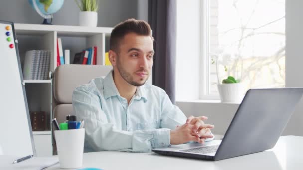 A fiatal tanár online leckét készít, miközben otthon ül a számítógép előtt. Az iskolai leckéket oktató munkahely. Távoli tanulás és oktatás koncepciója. — Stock videók