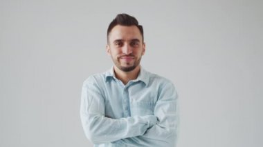 Genç Kafkasyalı Brunet Adam Açık Gri Arkaplanda Kameraya Bakıyor. Stüdyo Erkek Yüz Portresi. Doğal Gün Işığı.