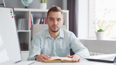 Genç Öğretmen evde bilgisayarın önünde otururken çevrimiçi ders veriyor. Okul Dersleri Öğretmeni 'nin İş Yeri. Uzaktan Eğitim ve Öğrenim Konsepti.