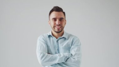 Genç Kafkasyalı Brunet Adam Açık Gri Arkaplanda Kameraya Bakıyor. Stüdyo Erkek Yüz Portresi. Doğal Gün Işığı.