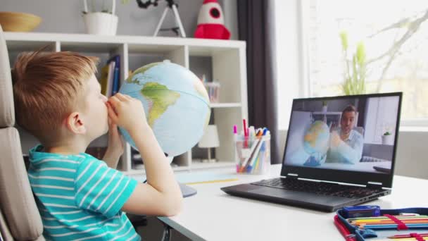 De jongen doet zijn huiswerk aan de tafel. Schattig kind is thuis leren met behulp van Laptop Computer en School leerboeken. Studie en afstandsonderwijs Concept. — Stockvideo