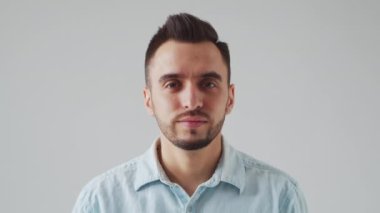 Genç Kafkas Brunet Sakallı Adam Açık Gri Arkaplan 'daki kameraya bakıyor. Stüdyo Erkek Yüz Portresi. Doğal Gün Işığı.