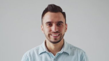 Genç Kafkas Brunet Sakallı Adam Açık Gri Arkaplan 'daki kameraya bakıyor. Stüdyo Erkek Yüz Portresi. Doğal Gün Işığı.