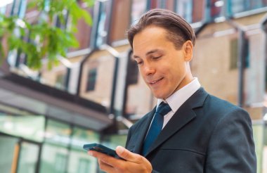 Modern ofis binasının önünde duran bir iş adamı. Dışarıdaki finans yatırımcısı. Bankacılık ve iş konsepti.