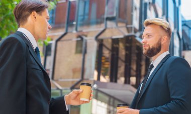 Modern ofis binasının önünde kendinden emin bir iş adamı ve meslektaşı. Formalite yatırımcıları dışarıda konuşuyorlar. Bankacılık ve iş konsepti.