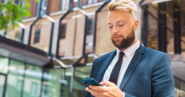 Modern ofis binasının önünde duran bir iş adamı. Dışarıdaki finans yatırımcısı. Bankacılık ve iş konsepti.