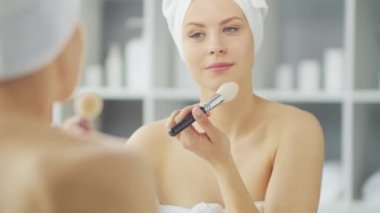 Genç Kız, Tuvalette Makyaj Aynası 'nın önünde oturuyor ve cilt kremi sürüyor. Güzel kadın kozmetik yenileme prosedürleri uyguluyor. Sağlık ve Güzellik Konsepti.