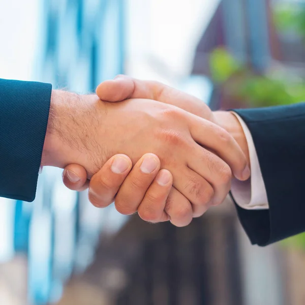 stock image Confident businessman and his colleague are shaking hands in front of modern office building. Financial investors outdoor. Banking and business concept.