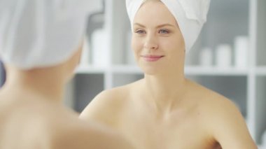 Genç Kız, Tuvalette Makyaj Aynası 'nın önünde oturuyor ve cilt kremi sürüyor. Güzel kadın kozmetik yenileme prosedürleri uyguluyor. Sağlık ve Güzellik Konsepti.