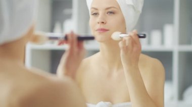 Genç Kız, Tuvalette Makyaj Aynası 'nın önünde oturuyor ve cilt kremi sürüyor. Güzel kadın kozmetik yenileme prosedürleri uyguluyor. Sağlık ve Güzellik Konsepti.