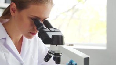 Kadın doktor, ekipman ve teknolojileri kullanarak modern bir bilim laboratuarında çalışıyor. Bilim adamı araştırma yapar ve yeni aşılar geliştirir. Bilim ve sağlık konsepti.