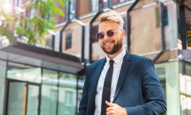 Modern ofis binasının önünde duran bir iş adamı. Dışarıdaki finans yatırımcısı. Bankacılık ve iş konsepti.