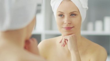 Genç Kız, Tuvalette Makyaj Aynası 'nın önünde oturuyor ve cilt kremi sürüyor. Güzel kadın kozmetik yenileme prosedürleri uyguluyor. Sağlık ve Güzellik Konsepti.