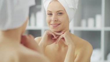 Genç Kız, Tuvalette Makyaj Aynası 'nın önünde oturuyor ve cilt kremi sürüyor. Güzel kadın kozmetik yenileme prosedürleri uyguluyor. Sağlık ve Güzellik Konsepti.