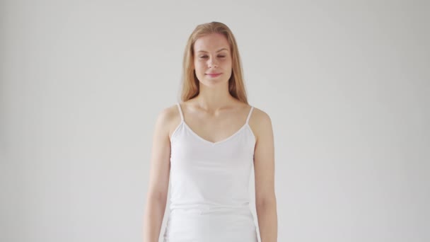Genç Güzel Sarışın Bir Kadın Gri Arka Planda Kameranın Önünde — Stok video