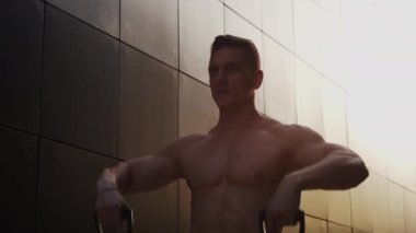 Sunset 'te spor yapan genç kaslı adam. Genç ve güçlü bir sporcunun eğitimi. Fitness ve Sağlıklı Yaşam Konsepti.