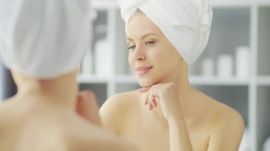 Genç Kız, Tuvalette Makyaj Aynası 'nın önünde oturuyor ve cilt kremi sürüyor. Güzel kadın kozmetik yenileme prosedürleri uyguluyor. Sağlık ve Güzellik Konsepti.