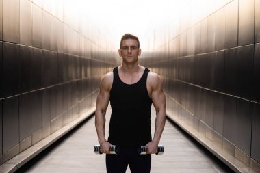 Sunset 'te spor yapan genç kaslı adam. Genç ve güçlü bir sporcunun eğitimi. Fitness ve Sağlıklı Yaşam Konsepti.