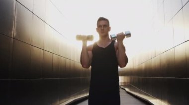 Sunset 'te spor yapan genç kaslı adam. Genç ve güçlü bir sporcunun eğitimi. Fitness ve Sağlıklı Yaşam Konsepti.