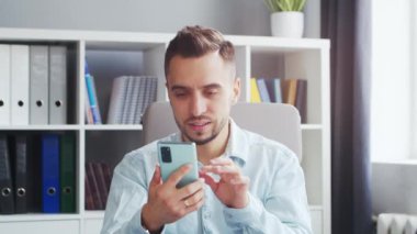 Genç adam evde bir bilgisayarın önünde otururken çalışıyor. Profesyonel bir işçinin, serbest çalışanın ya da öğrencinin işyeri. Mesafe Çalışma ve Eğitim Konsepti.