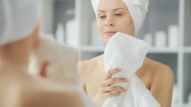 Genç Kız, Tuvalette Makyaj Aynası 'nın önünde oturuyor ve cilt kremi sürüyor. Güzel kadın kozmetik yenileme prosedürleri uyguluyor. Sağlık ve Güzellik Konsepti.