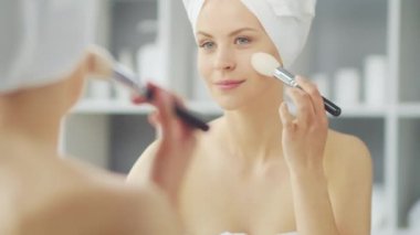 Genç Kız, Tuvalette Makyaj Aynası 'nın önünde oturuyor ve cilt kremi sürüyor. Güzel kadın kozmetik yenileme prosedürleri uyguluyor. Sağlık ve Güzellik Konsepti.