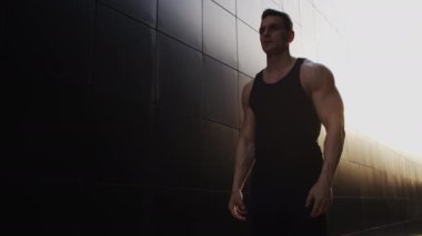 Sunset 'te spor yapan genç kaslı adam. Genç ve güçlü bir sporcunun eğitimi. Fitness ve Sağlıklı Yaşam Konsepti.