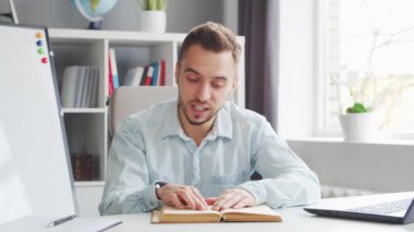 Genç Öğretmen evde bilgisayarın önünde otururken çevrimiçi ders veriyor. Profesyonel Okul Dersleri Öğretmeni 'nin İş Yeri. Uzaktan Eğitim ve Öğrenim Konsepti.