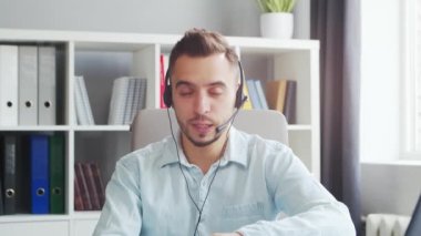 Young Man Works while Sitting in front of a Computer at Home. The Workplace of a Professional Worker, Freelancer or Student. The Concept of Distance Work and Education.