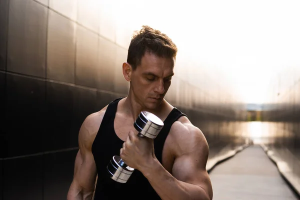 Young Muscular Man Doing Sports Outside at Sunset. Training of a Young Strong Athlete. The Concept of Fitness and Healthy Lifestyle.