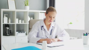 Doktor muayenehanede çalışıyor. Beyaz Önlüklü Kadın. Bir hastanede ya da klinikte profesyonel bir kadın terapistin işyeri. Sağlık ve Tıp Konsepti.